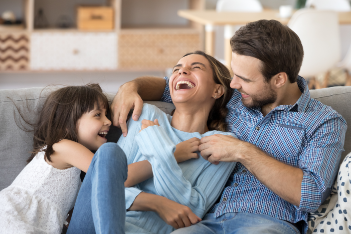 family laughing on the couch a home