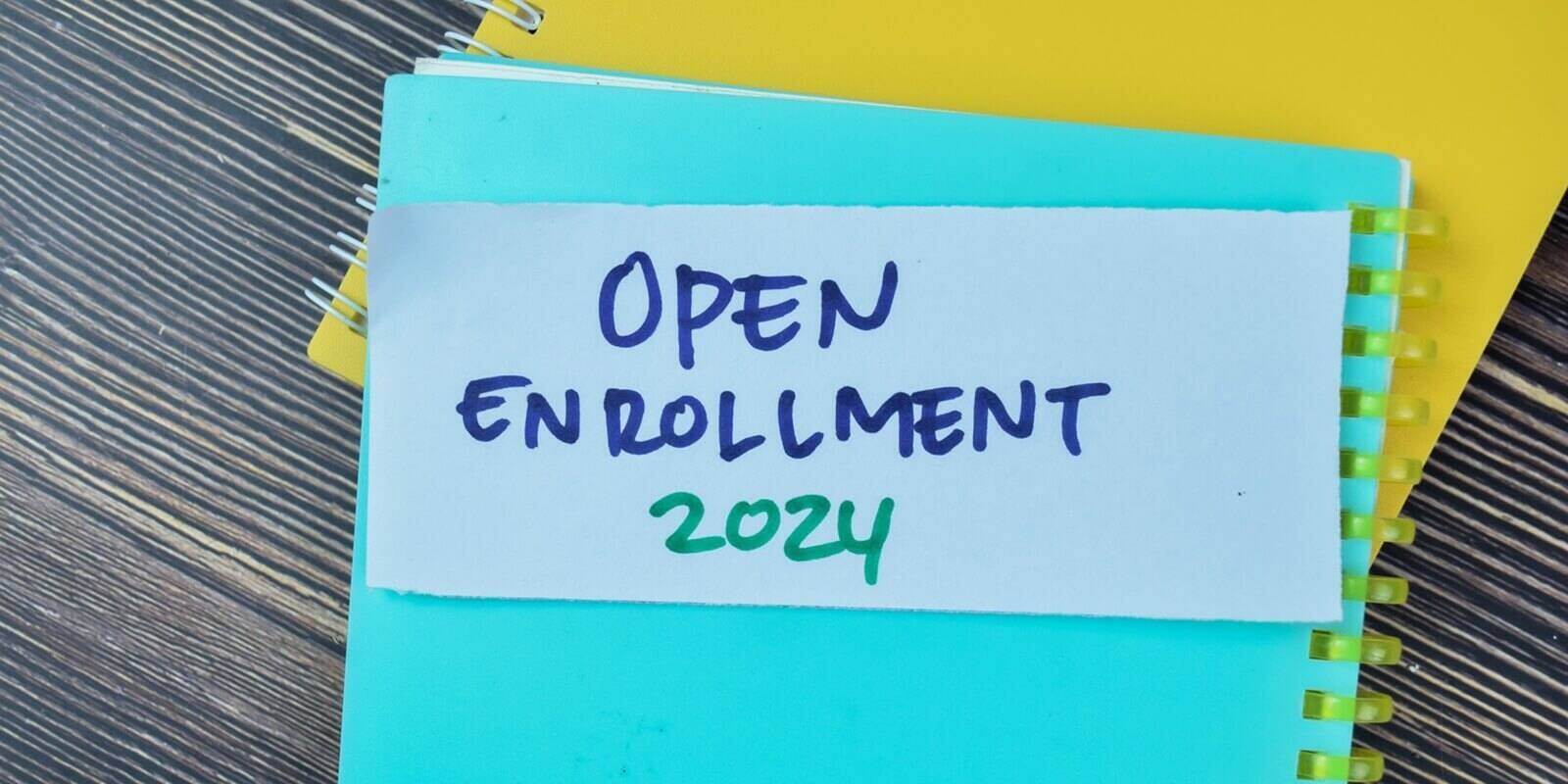 concept of open enrollment 2024 write on sticky notes isolated on wooden table